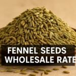 Fennel seeds wholesale rate written on a mound of fresh green fennel seeds in a brown bowl